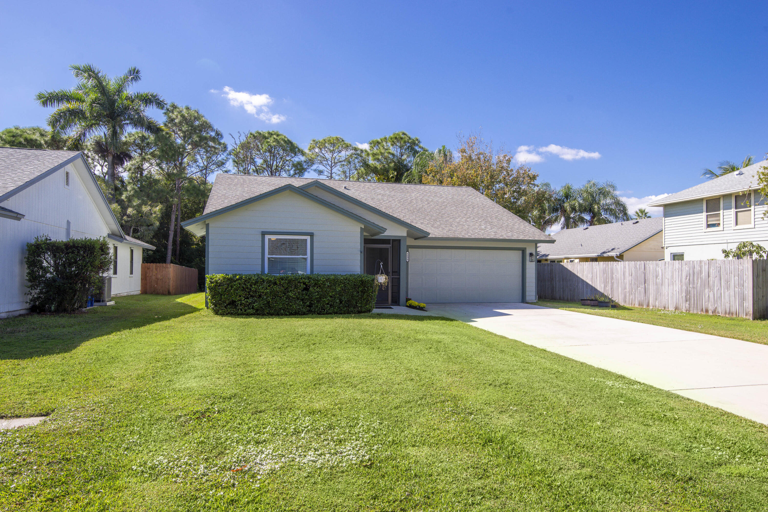 6690 Southeast Raintree Avenue Stuart, FL 34997 - Photo 34 of 43 a yellow house with a yard and a large tree