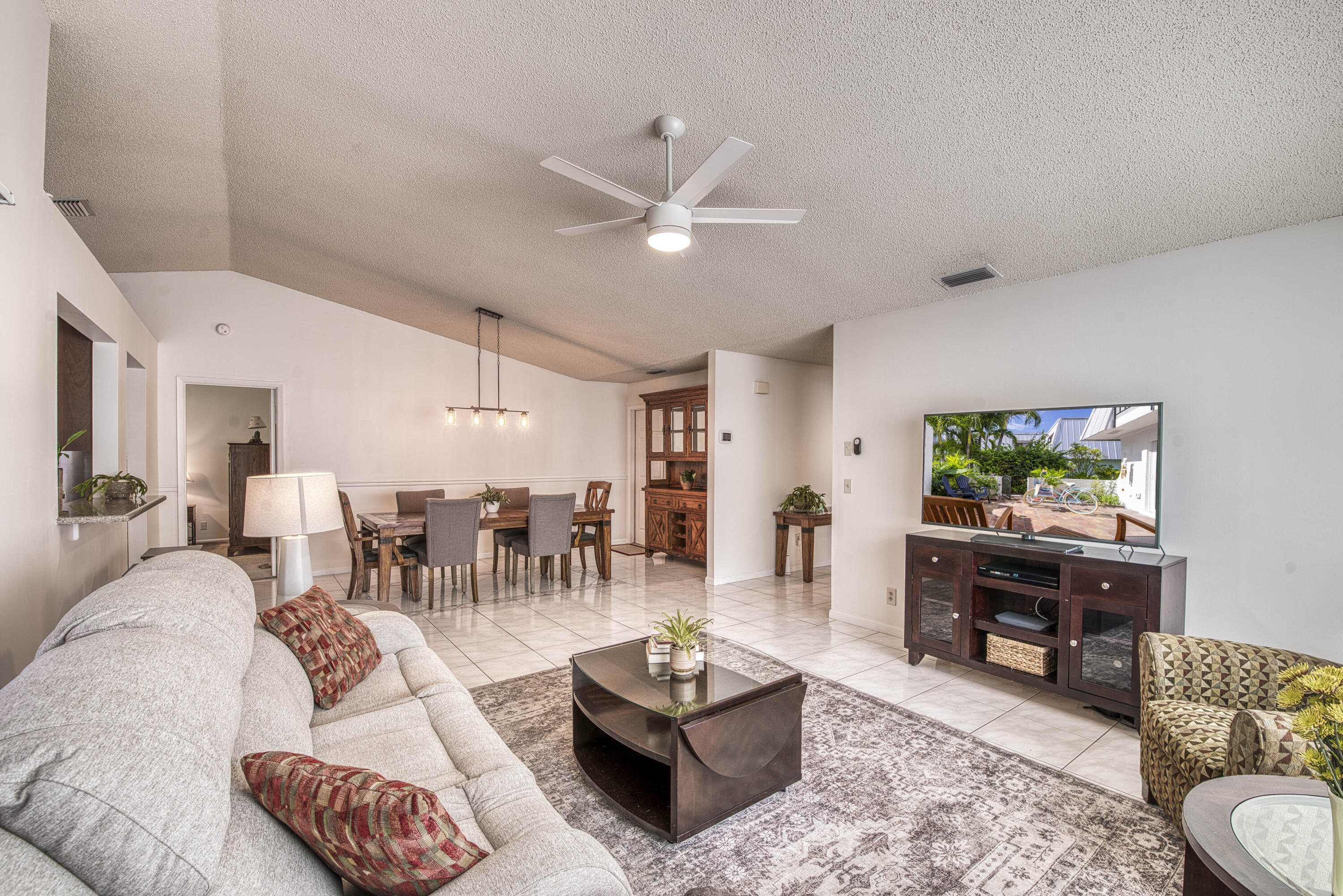 6690 Southeast Raintree Avenue Stuart, FL 34997 - Photo 7 of 43 a living room with furniture and a flat screen tv