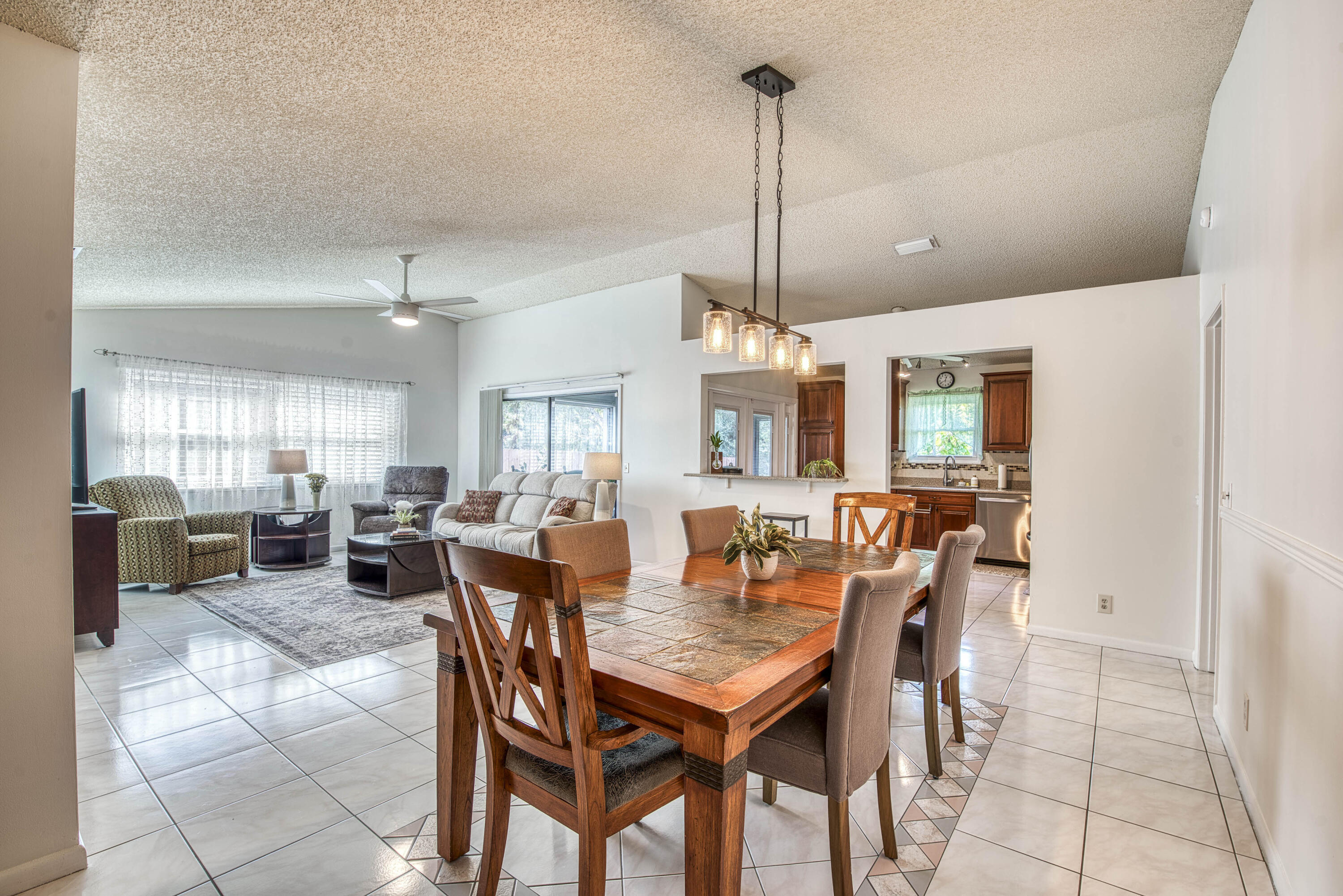 6690 Southeast Raintree Avenue Stuart, FL 34997 - Photo 10 of 43 a view of a dining room and livingroom with furniture wooden floor a chandelier