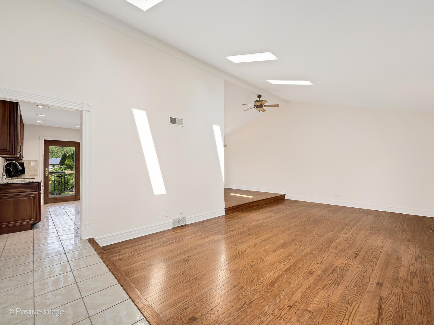 11S568 Book Road Naperville, IL 60564 - Photo 7 of 25 a view of a livingroom with wooden floor and a ceiling fan
