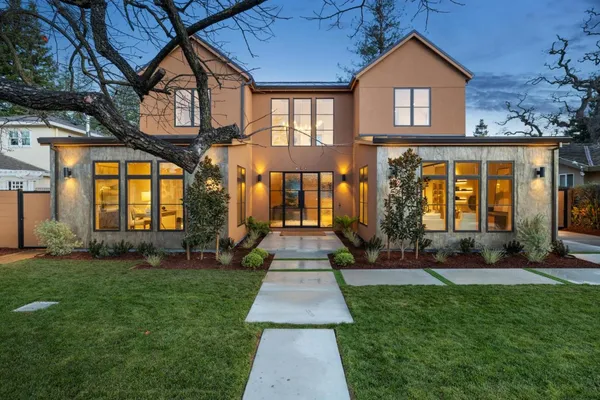 a front view of a house with a yard and potted plants