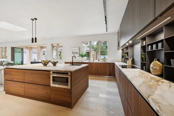 a kitchen with stainless steel appliances granite countertop a stove and a large window