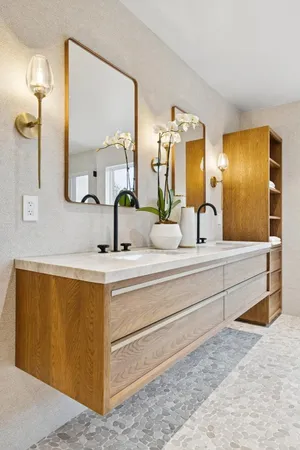 a bathroom with double vanity sinks and a mirror