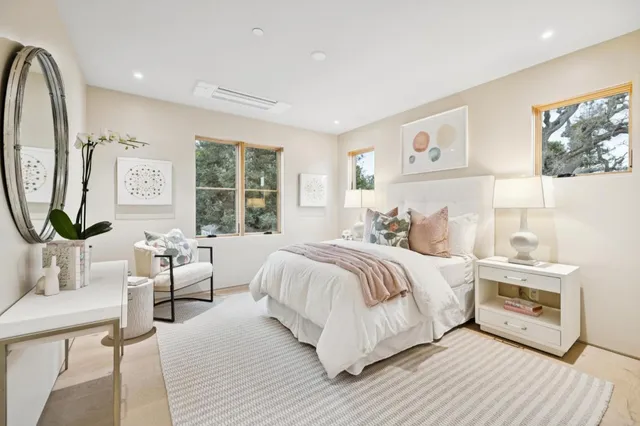 a bedroom with a bed a mirror and a large window