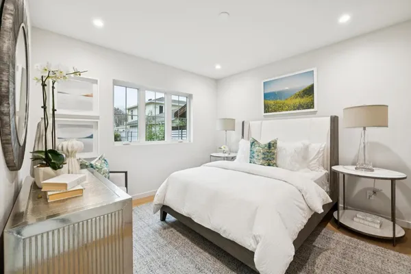 a bedroom with a bed a mirror and a window