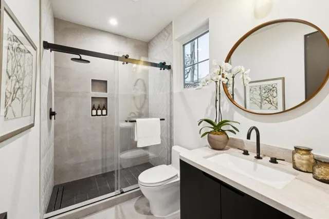 a bathroom with a sink a toilet and shower