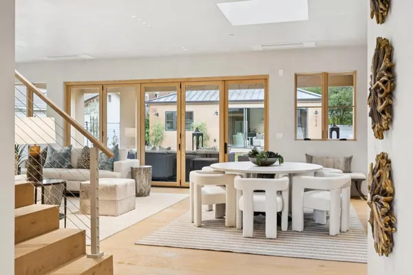 a view of a dining room with furniture a chandelier and wooden floor