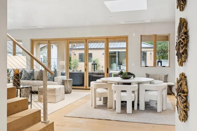 a view of a dining room with furniture a chandelier and wooden floor