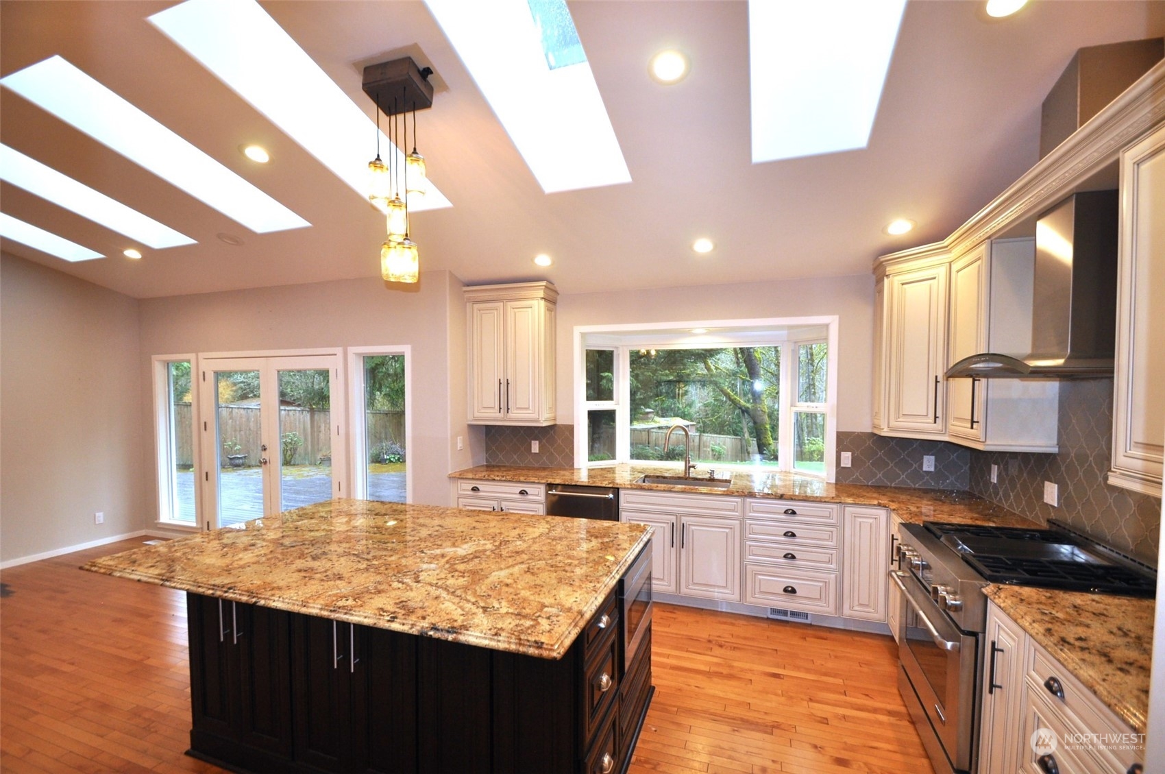 13003 Lake Kathleen Road Southeast Renton, WA 98059 - Photo 2 of 13 a kitchen with kitchen island granite countertop a stove a sink and a refrigerator