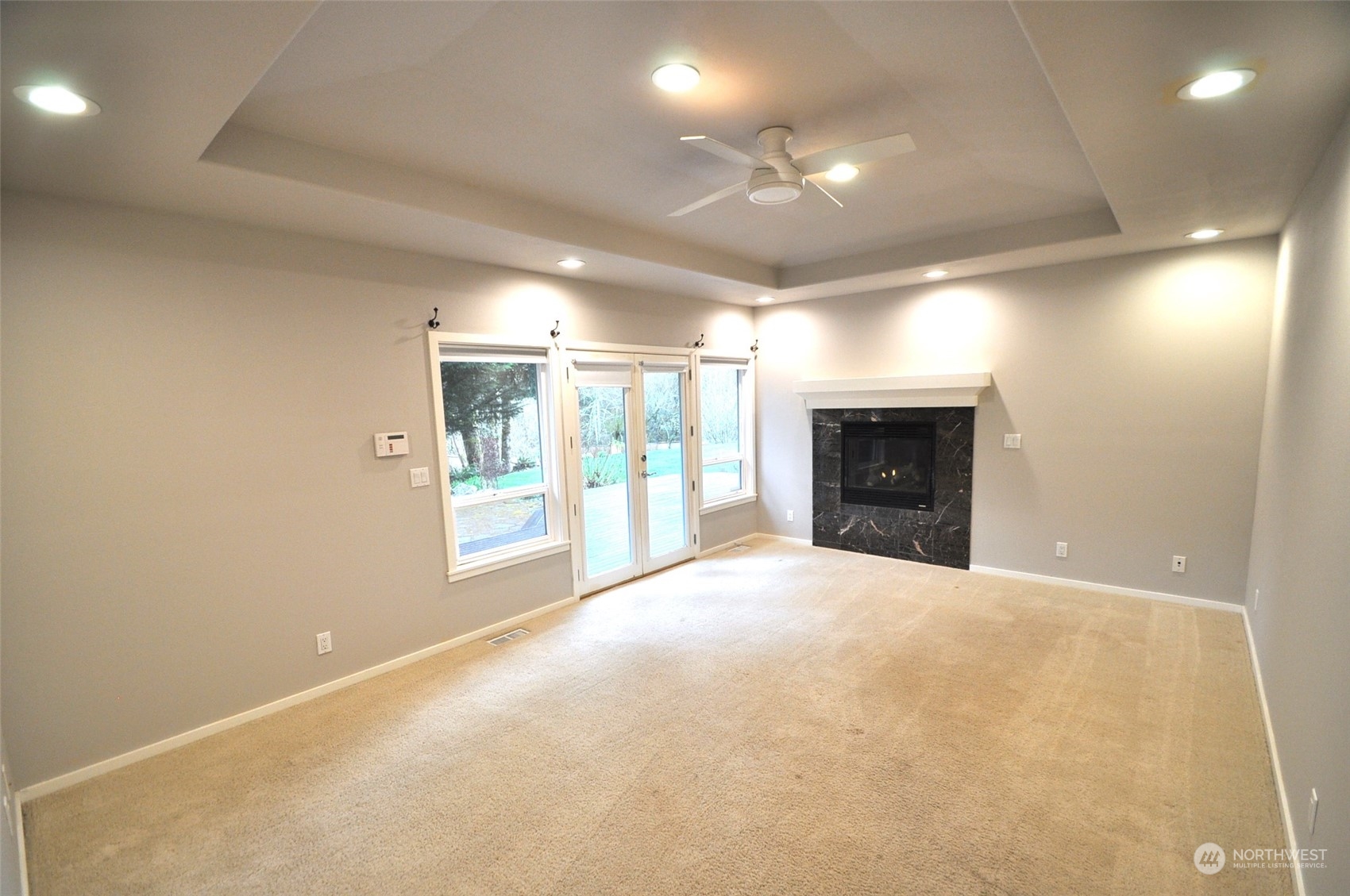 13003 Lake Kathleen Road Southeast Renton, WA 98059 - Photo 7 of 13 an empty room with windows and fireplace