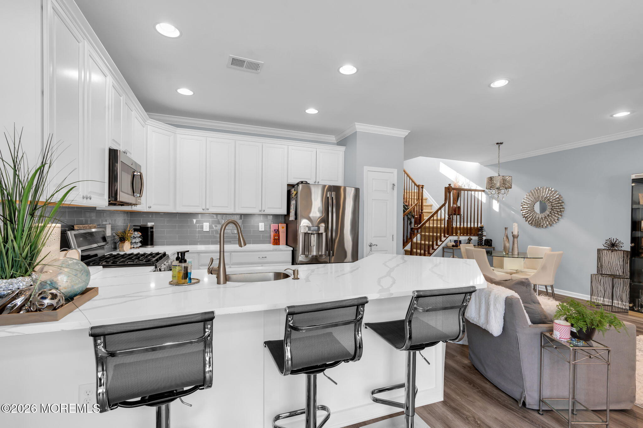 62 Santa Rosa Lane Tinton Falls, NJ 07753 - Photo 10 of 23 a kitchen with stainless steel appliances kitchen island granite countertop a refrigerator a stove a sink a dining table and chairs with wooden floor