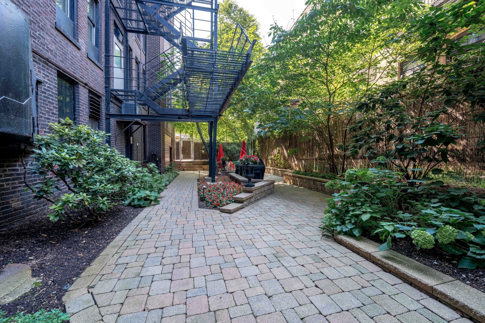 20 East Cedar Street, Unit 6E Chicago, IL 60611 - Photo 35 of 35 a view of a patio with table and chairs potted plants and large tree