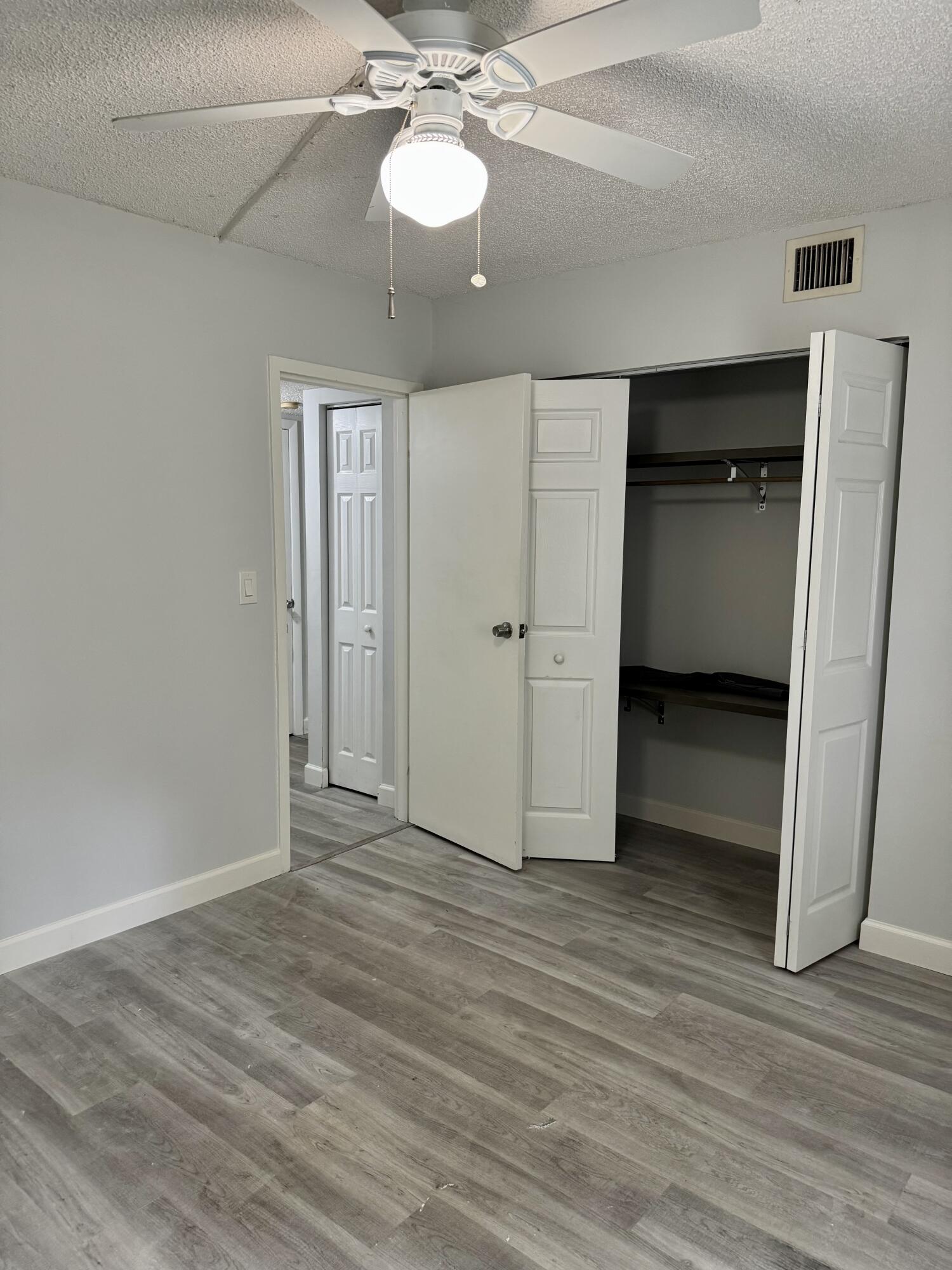912 Southwest 9th St Circle, Unit 101 Boca Raton, FL 33486 - Photo 19 of 25 wooden floor in an empty room with a window