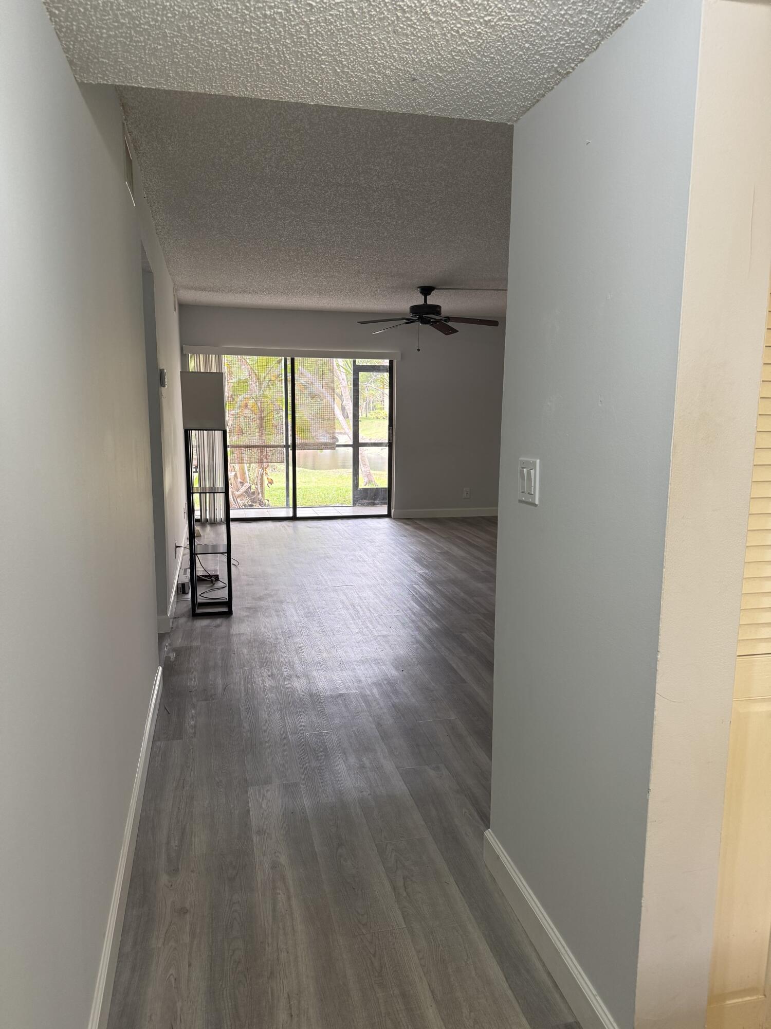 912 Southwest 9th St Circle, Unit 101 Boca Raton, FL 33486 - Photo 4 of 25 an empty room with wooden floor and windows