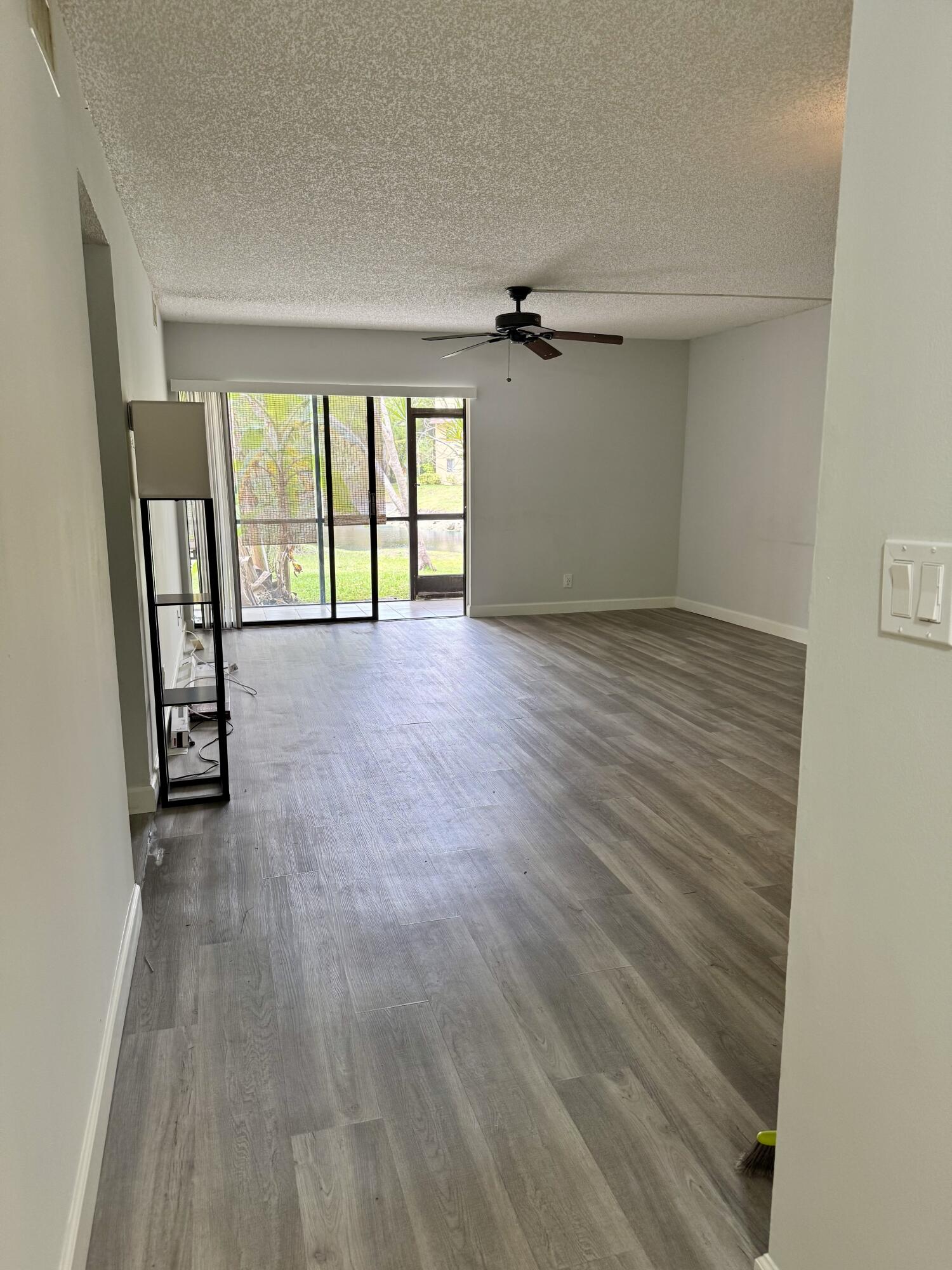 912 Southwest 9th St Circle, Unit 101 Boca Raton, FL 33486 - Photo 5 of 25 wooden floor in an empty room with a window
