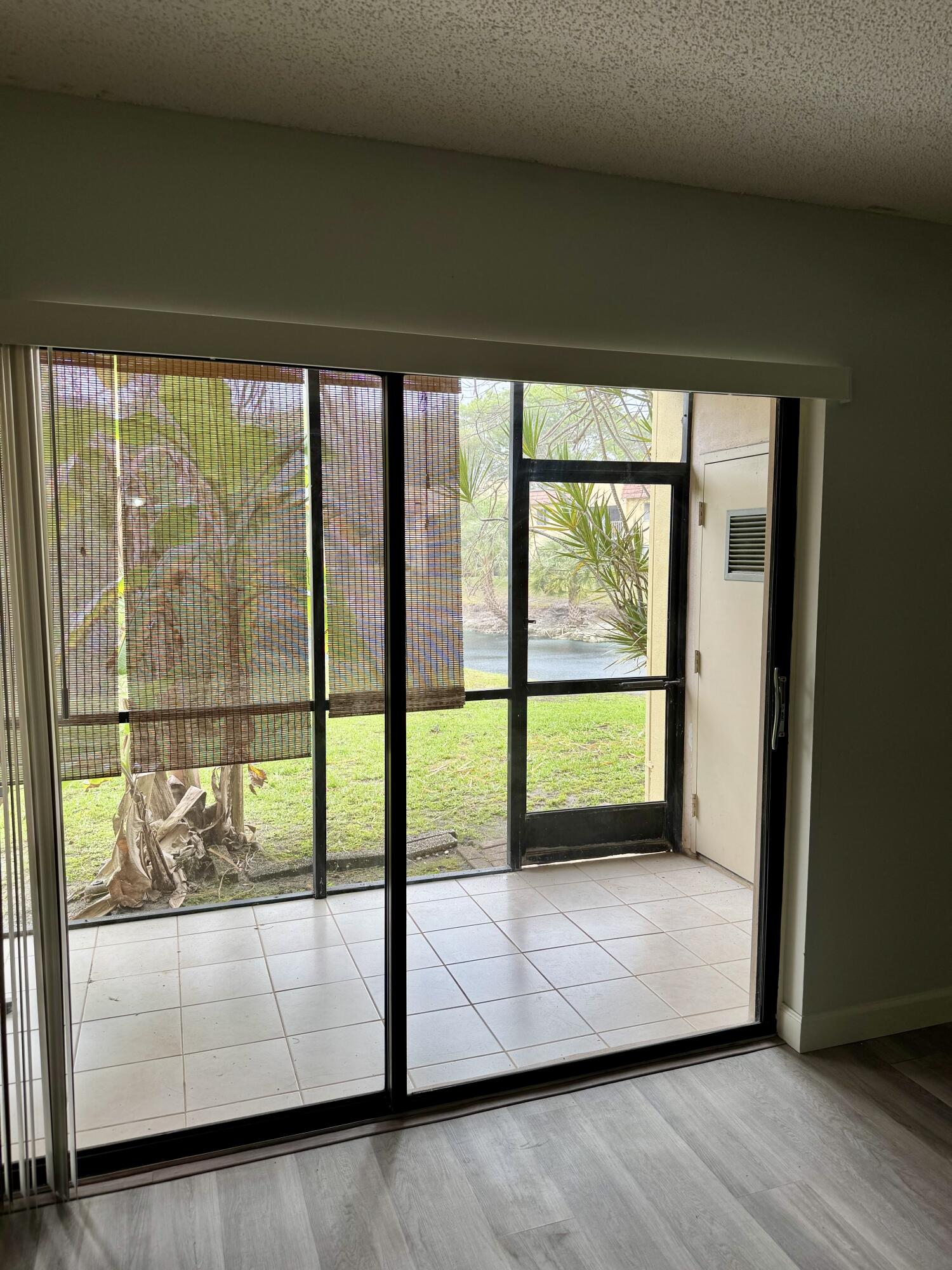 912 Southwest 9th St Circle, Unit 101 Boca Raton, FL 33486 - Photo 7 of 25 a view of an empty room with wooden floor and a floor to ceiling window