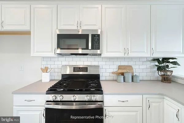 a stove top oven sitting inside of a kitchen