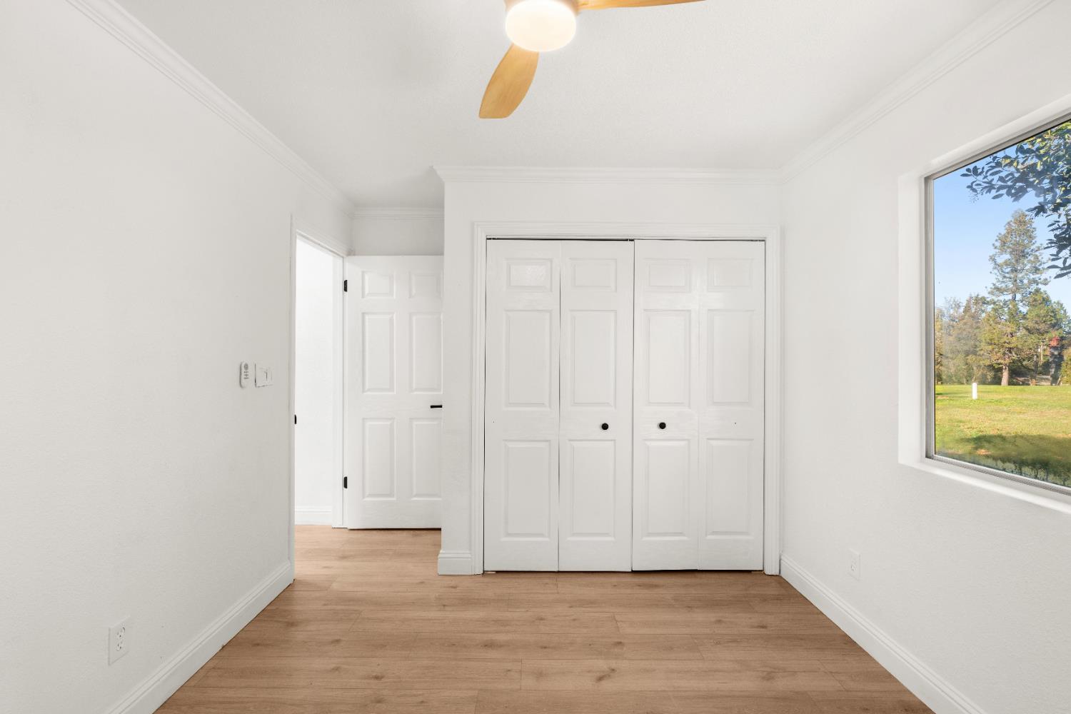 24626 Oro Valley Road Auburn, CA 95602 - Photo 32 of 54 a view of an empty room with wooden floor and a window