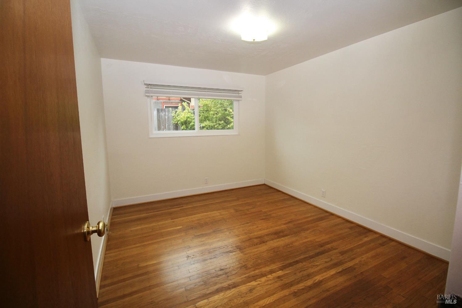 599 Tamarack Drive San Rafael, CA 94903 - Photo 19 of 20 an empty room with wooden floor and window