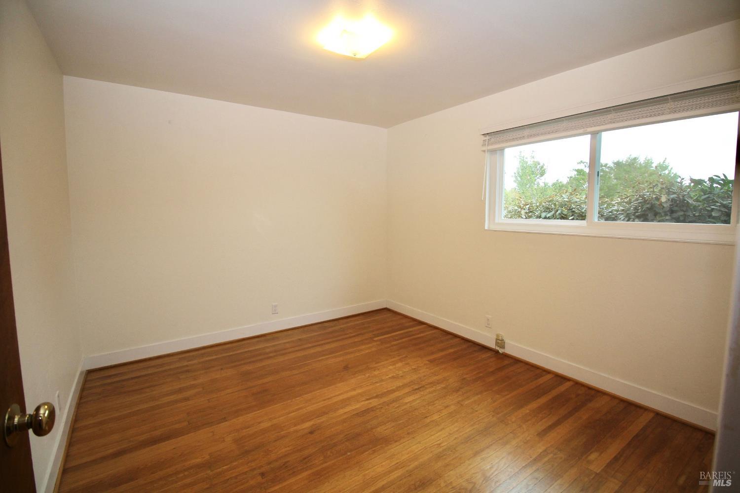 599 Tamarack Drive San Rafael, CA 94903 - Photo 7 of 20 an empty room with wooden floor and windows