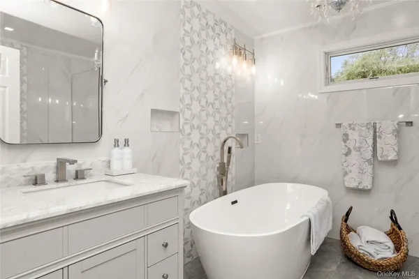a white bath tub sitting next to a bathroom sink