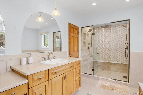 a bathroom with a sink a shower and a mirror