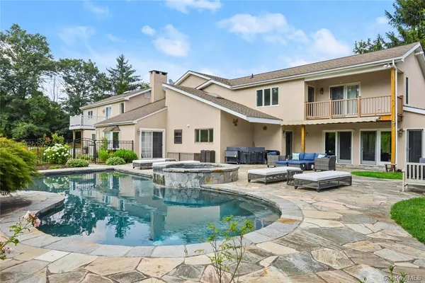 a view of a house with backyard and sitting area
