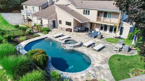 a view of a backyard with couches plants and large tree