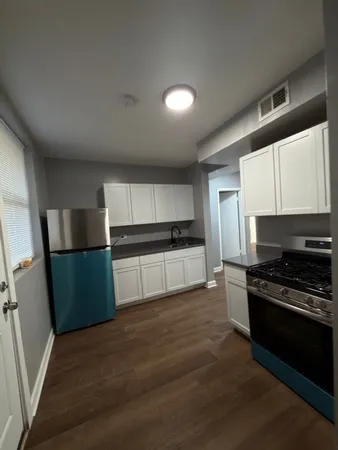 a kitchen with granite countertop a refrigerator and a stove top oven