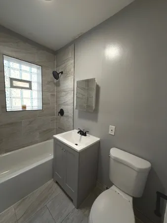 a bathroom with a sink toilet vanity and bathtub