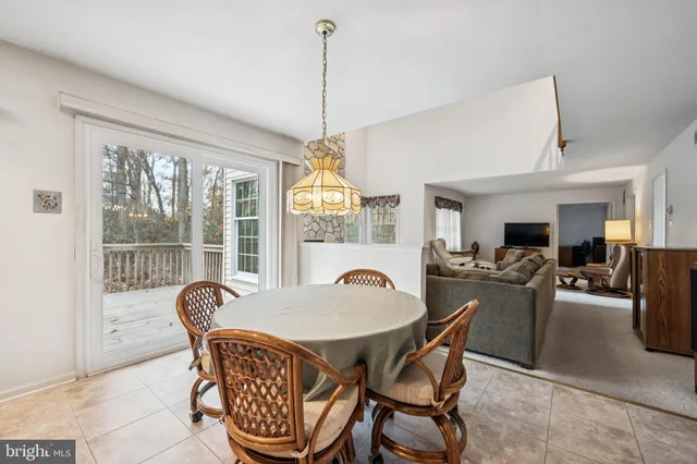 a dining room with furniture a chandelier and wooden floor
