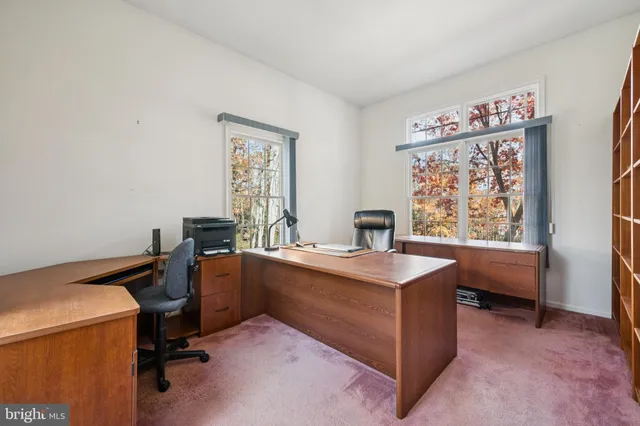 a view of a workspace with furniture and a window