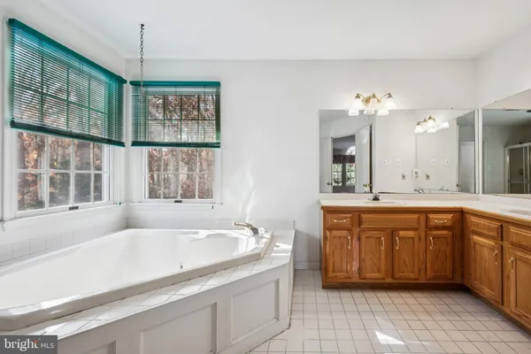 a spacious bathroom with a granite countertop tub sink and mirror