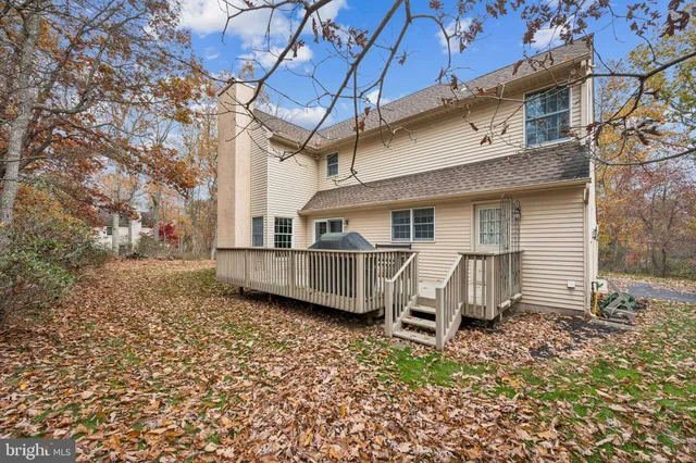 a view of a house with a big yard and large tree