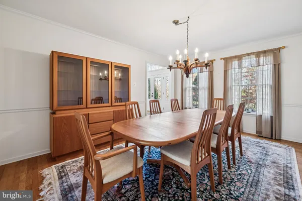a dining room with furniture a chandelier and wooden floor