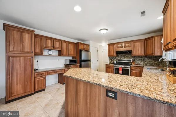 a kitchen with stainless steel appliances granite countertop a refrigerator stove top oven a sink and dishwasher