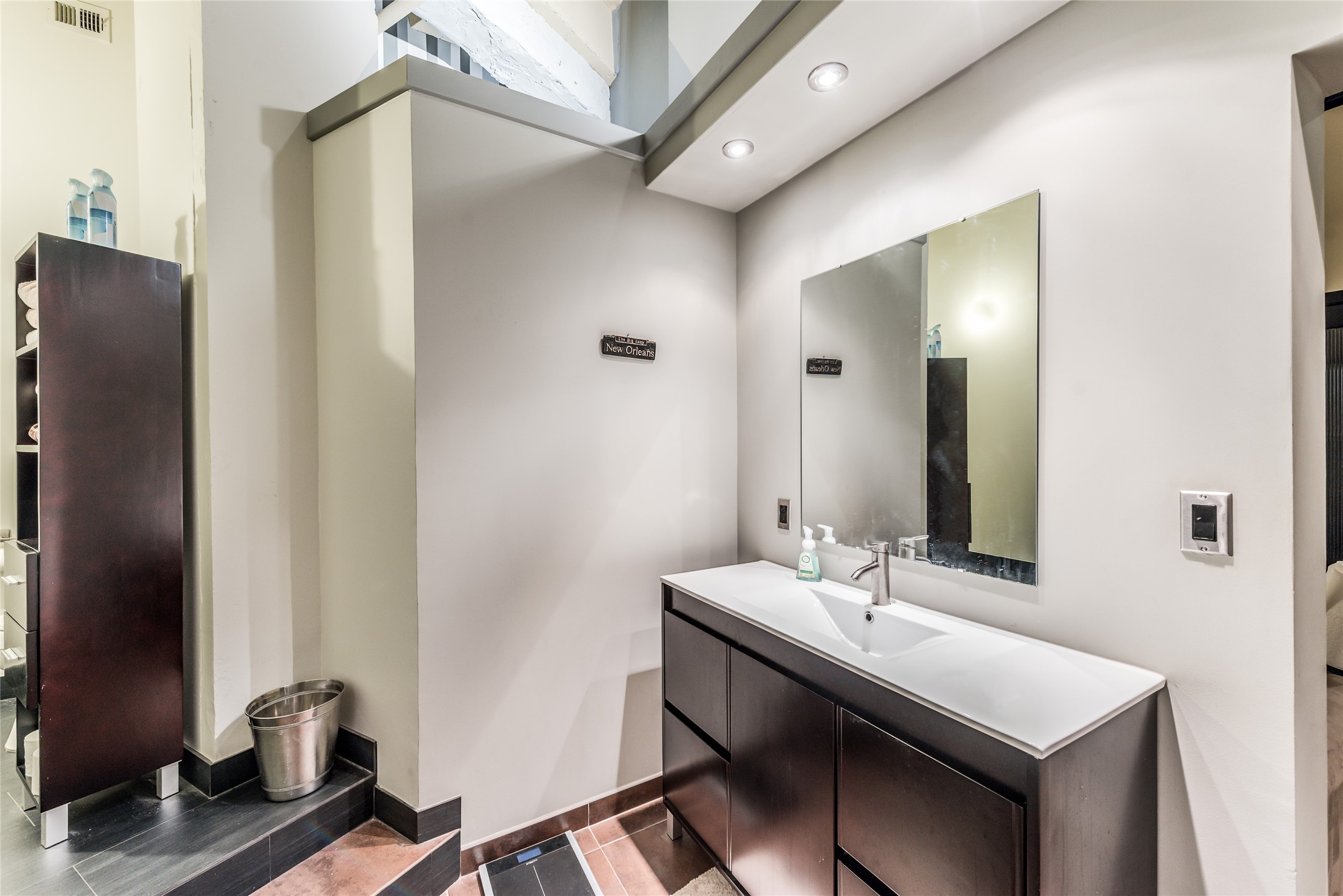 705 Main Street, Unit 215 Houston, TX 77002 - Photo 17 of 36 Secondary Bathroom features a modern vanity with a large mirror, recessed lighting, and sleek cabinetry.