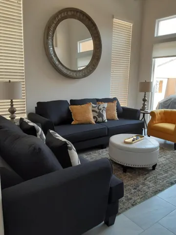 a living room with couches and a mirror