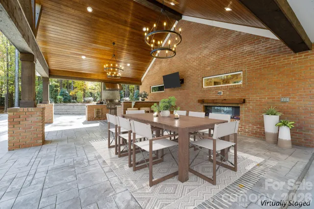 a view of a patio with dining table and chairs with a barbeque grill and couches