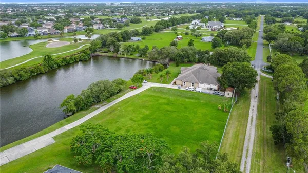 an aerial view of residential houses with outdoor space and lake view
