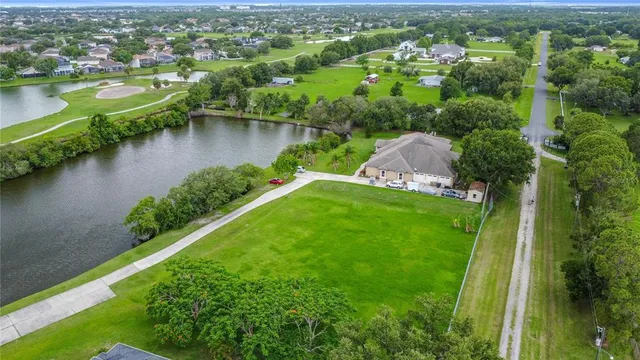 an aerial view of residential houses with outdoor space and lake view