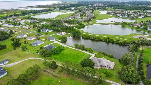 an aerial view of residential houses with outdoor space and lake view
