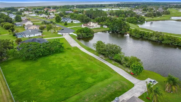 an aerial view of residential houses with outdoor space and trees