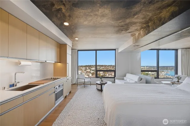 a large kitchen with stainless steel appliances a large counter top a stove and a refrigerator