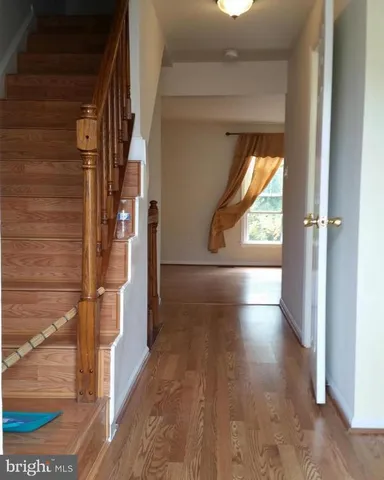 a view of hallway with wooden floor and a rug