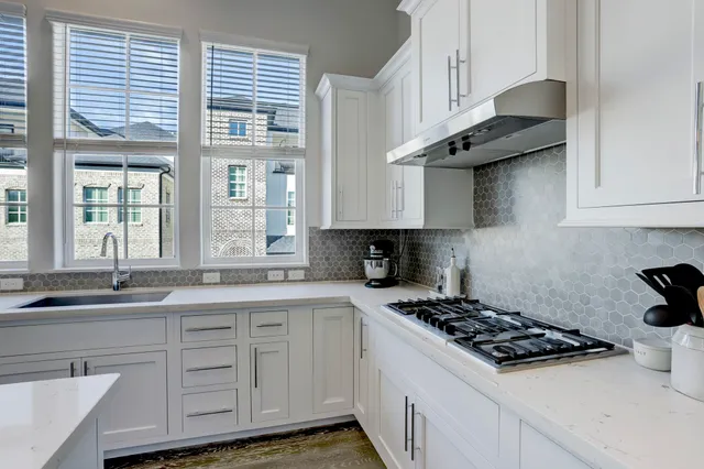 a kitchen with stainless steel appliances granite countertop a sink stove and cabinets