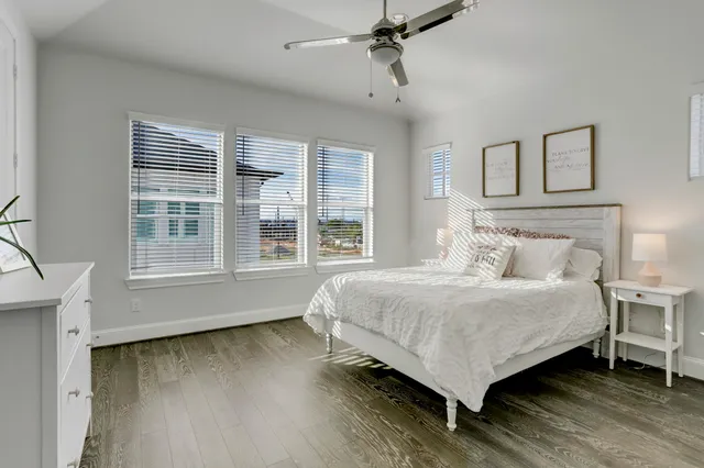 a bedroom with a bed wooden floor and window