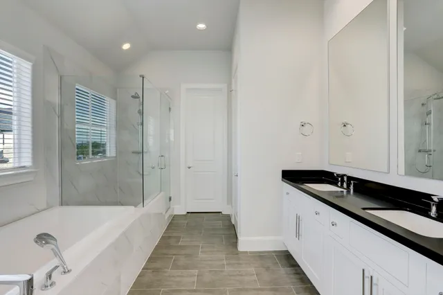 a spacious bathroom with a granite countertop tub a sink and a mirror