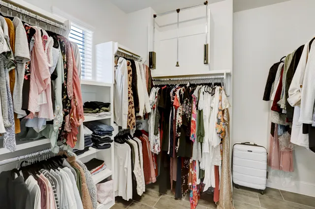 a view of walk in closet with clothes