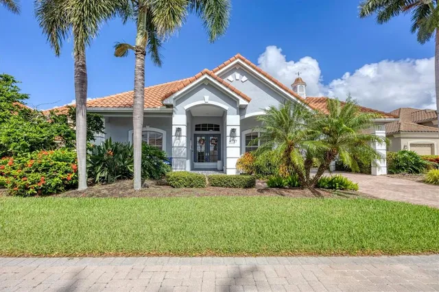 a view of a house with a yard and potted plants